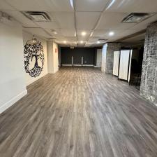Photo of open studio space with grey flooring and yoga decor